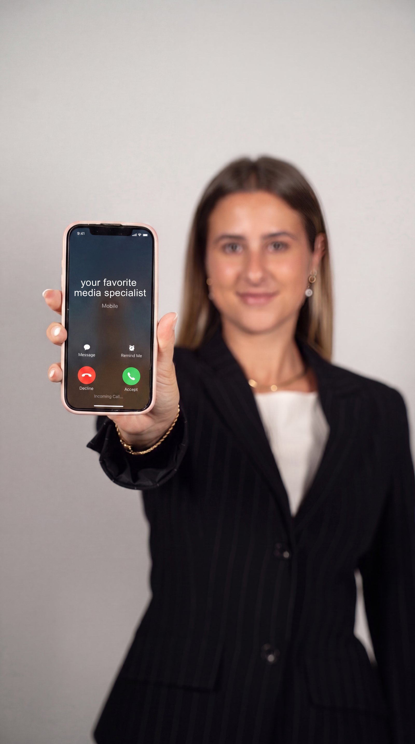Amélie zeigt Smartphone mit eingehendem Anruf: your favorite media specialist